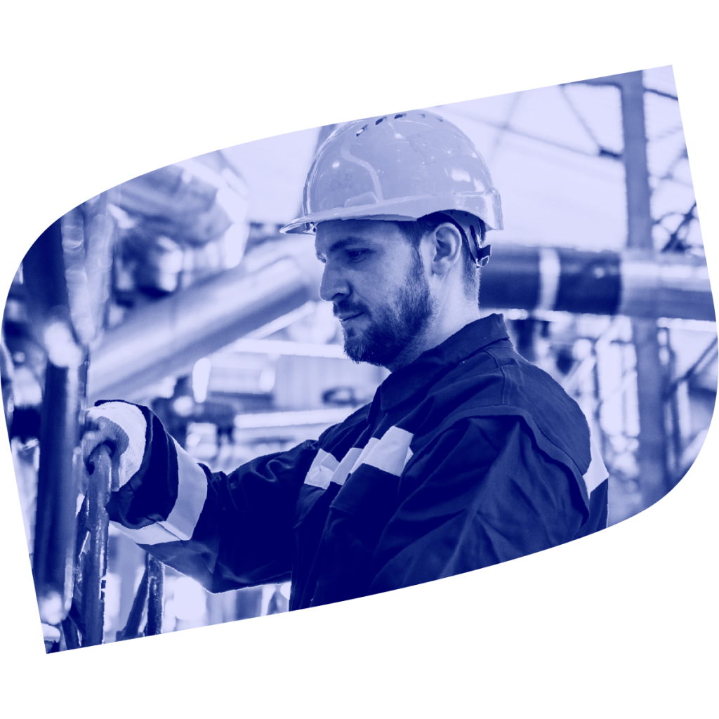 Male worker in factory looks down while holding a gear